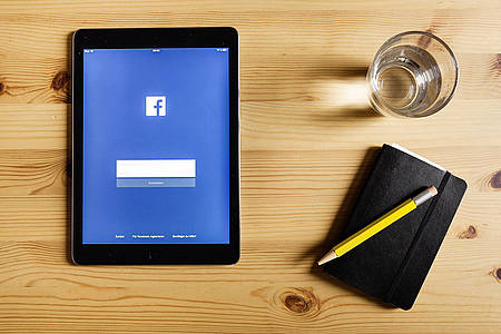 Tablet mit Facebook-Loginseite liegt auf einem Tisch