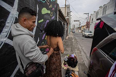 Der Fotograf hilft Lidya Gualano (M.) beim Umziehen auf der Straße, wo sie das Auto voller Kleider geparkt haben.