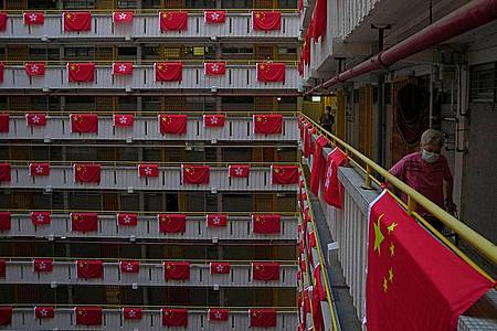Anlässlich der Feierlichkeiten des 25. Jahrestags der Übergabe Hongkongs an China ist dieses Wohnhaus mit chinesischen und Fahnen der Sonderverwaltung Hongkong dekoriert.