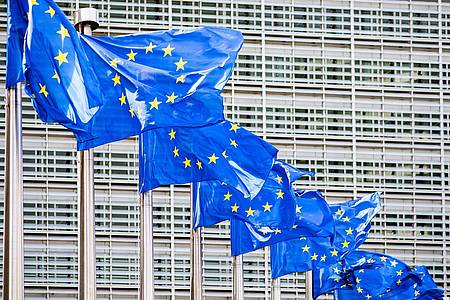 Europaflaggen flattern vor dem Sitz der Europäischen Kommission in Brüssel. Die Chefs von 20 europäischen Telekommunikationsunternehmen appellieren an die EU, große Tech-Konzerne zu höheren Zahlungen für die Nutzung der Netze zu verpflichten.