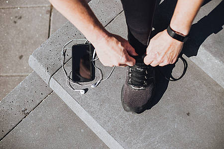 Mann bindet sich seinen Laufschuh